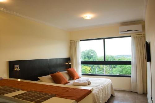 a bedroom with a large bed with a large window at Rio Manso Apartamentos in Victoria