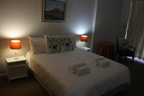 a bedroom with a bed with two towels on it at Bloubergviews in Bloubergstrand