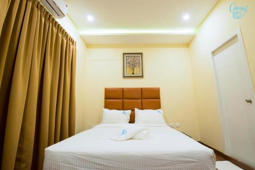 a bedroom with a bed with two towels on it at Caramel Hotels in Bangalore