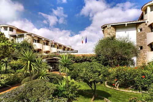 a view of the front of a hotel with plants at Grand Hotel Smeraldo Beach in Baja Sardinia