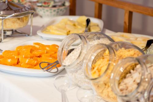 ヴィラモウラにあるApartamentos Turisticos Pinhal Da Marinaの果物の皿と食べ物の瓶が置かれたテーブル