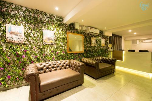 a lobby with two couches and a wall covered in flowers at Caramel Hotels in Bangalore