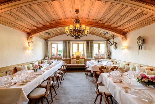 a dining room with tables and chairs and a chandelier at Bauer Hotel und Restaurant in Feldkirchen