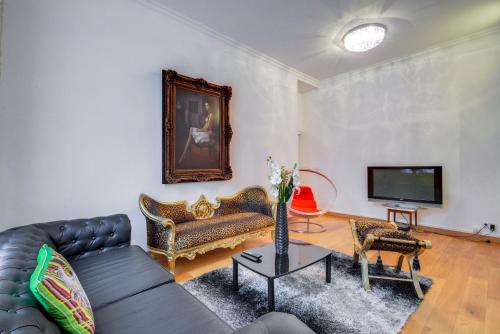 a living room with a couch and a tv at PRESIDENTIAL SUITE 11 FOCH Av-in Arc de Triomphe in Paris