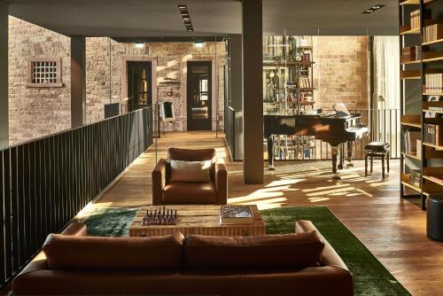 a living room with a couch and a piano at Hotel Liberty Offenburg in Offenburg