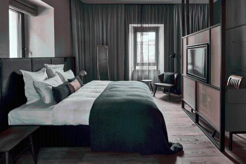 a bedroom with a large bed and a television at Hotel Liberty Offenburg in Offenburg
