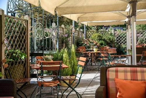 an outdoor patio with tables and chairs and umbrellas at Bauer Hotel und Restaurant in Feldkirchen
