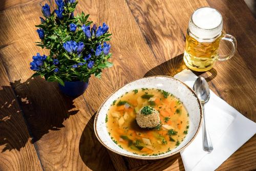 a bowl of soup and a glass of beer on a table at Bauer Hotel und Restaurant in Feldkirchen