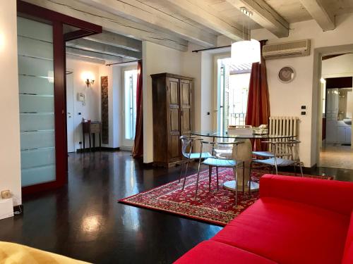 a living room with a red couch and a table at San Nicolò 3 in Verona