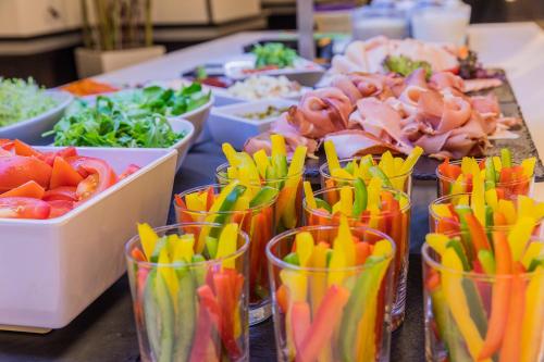 a table topped with cups filled with different types of food at Hotel President in Budapest