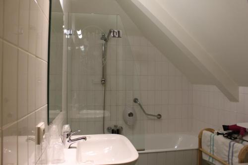 a bathroom with a sink and a shower at Hotel Des Bains in Lancieux