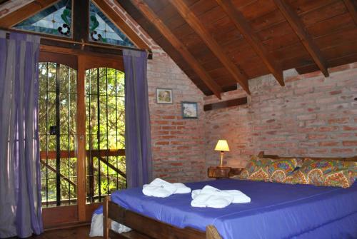 a bedroom with a blue bed and a window at Cabañas Poetas del Bosque in Mar Azul