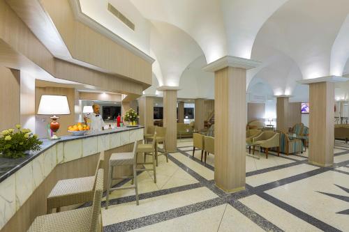 a lobby with chairs and a bar in a building at Hari Club Beach Resort in Aghīr