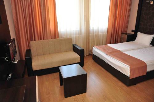 a hotel room with a bed and a chair at Luxor Complex in Ivaylovgrad