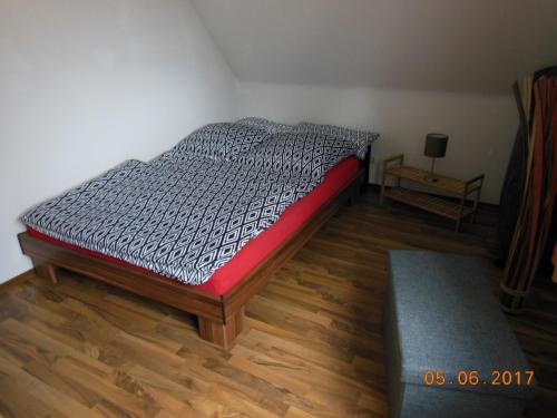 Bett in einem Zimmer mit Holzboden in der Unterkunft Ferienwohnung E.F. Schaper in Stadtoldendorf