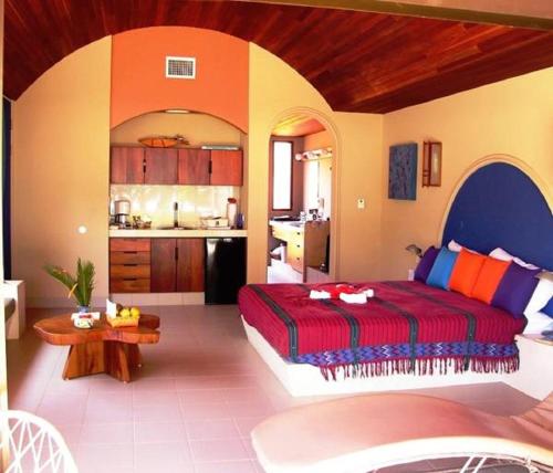 a bedroom with a large bed and a kitchen at Alma del Pacifico Hotel & Spa in Esterillos Este