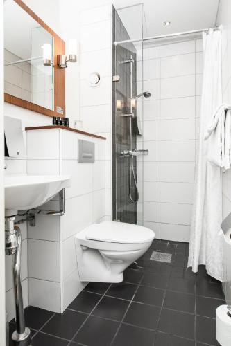 a bathroom with a toilet and a sink and a shower at Home Hotel Kung Oscar in Trollhättan