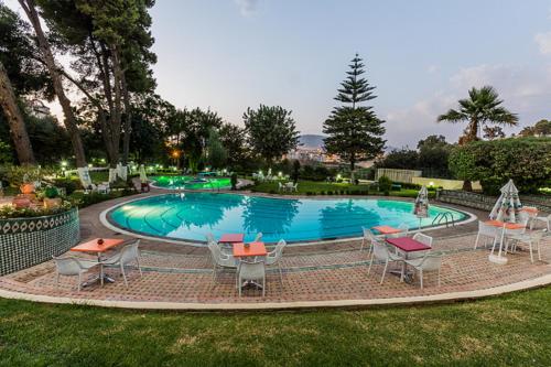 een zwembad met tafels en stoelen in een tuin bij Menzeh Zalagh 2Boutique Hôtel & Sky in Fès