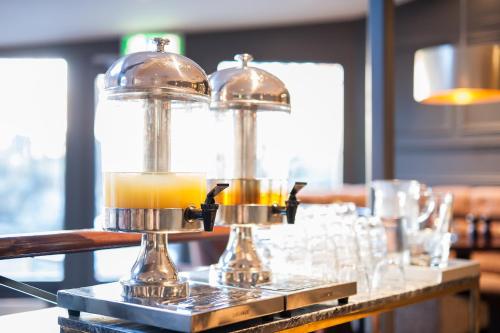 two glass containers of orange juice on a table at Home Hotel Kung Oscar in Trollhättan
