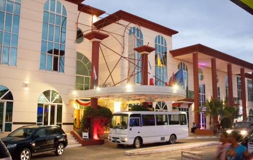 un bus blanc garé devant un bâtiment dans l'établissement Le Grand Hôtel Diego, à Diego Suarez