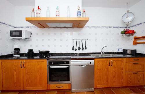 a kitchen with wooden cabinets and a stainless steel oven at Quality Villa Sa Tapia in Porreres