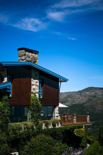 a house on a hill with mountains in the background at Pousada Geres-Caniçada in Geres