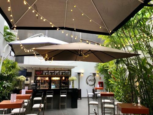 a bar with tables and chairs and an umbrella at Aku Hotels in Lima