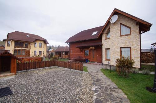 a home with a wooden fence and a yard at Panorama Yasinya in Yasinya