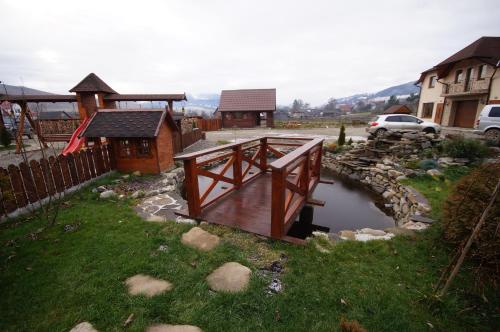 a wooden bridge over a small stream in a yard at Panorama Yasinya in Yasinya