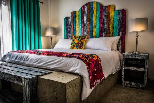 Dormitorio con cama grande y cabecero colorido en María de Nadie "Hotel Boutique", en Ciudad Constitución