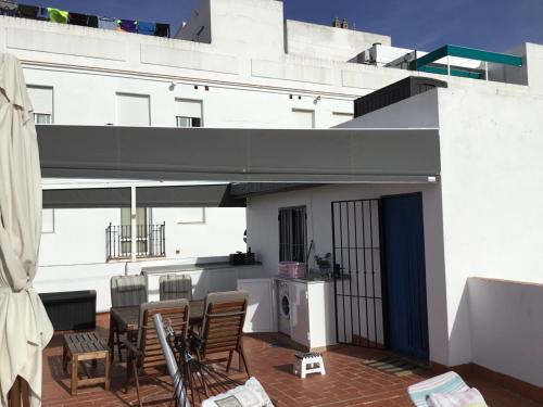 a balcony with chairs and a table on a building at Casa Sandra in Arcos de la Frontera