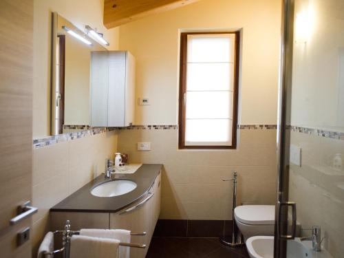 a bathroom with a sink and a toilet and a mirror at Casa Reit in Bormio