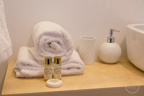 een badkamer met een handdoek en een fles lotion bij Hello Porto Ceuta Residences in Porto
