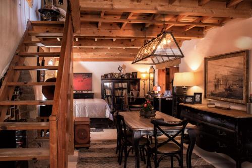 a room with a staircase and a table with chairs at CASA FELICIA-The Castle Mansion in Monemvasia