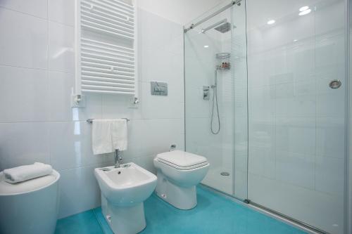 a white bathroom with a toilet and a shower at Tra Le Braccia di Morfeo in Terrasini