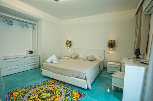 a bedroom with a white bed and a rug at Tra Le Braccia di Morfeo in Terrasini