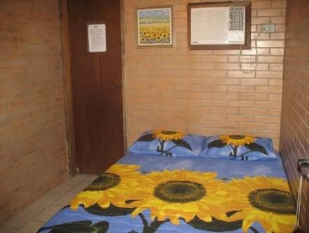 a bedroom with a bed with sunflowers on it at Pousada do Carlito in Ilha do Mel
