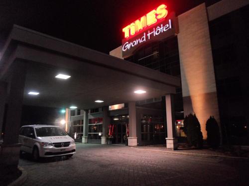 a car parked in front of a car dealership at night at Grand Times Hotel – Aeroport de Quebec in Quebec City