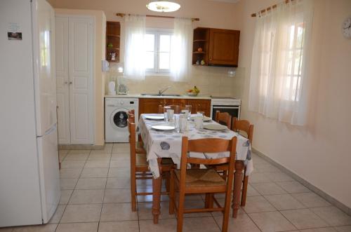 a kitchen with a table with chairs and a white table cloth at Villa Clementine in Gaios