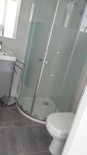 une salle de bain avec toilettes et douche en verre dans l'établissement le cube cassiopée, au Cap d'Agde