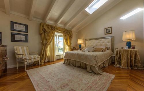a bedroom with a bed and a chair and a window at Villa Rinaldi in Montespertoli