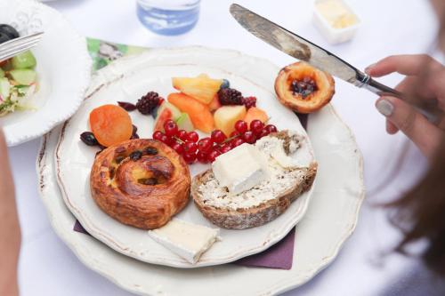 a plate of food with bread and fruit on it at B&B Cimbarsaca in Semmerzake