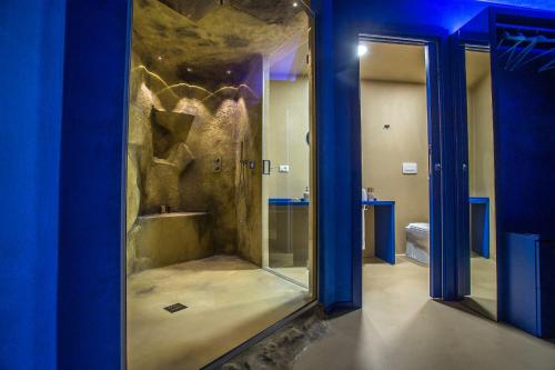 a bathroom with a shower with blue walls and a mirror at Tra Le Braccia di Morfeo in Terrasini