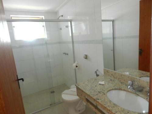 W łazience znajduje się toaleta, umywalka i prysznic. w obiekcie Príncipe Hotel w mieście Poços de Caldas