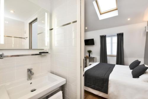 una camera da letto con un letto, un lavandino e uno specchio di Hotel Résidence Montebello a Parigi