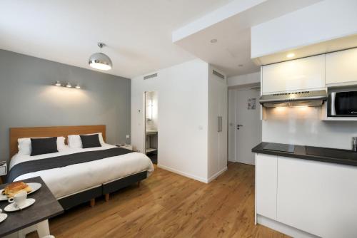 une chambre d'hôtel avec un lit et une cuisine dans l'établissement Hotel Résidence Montebello, à Paris