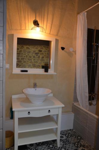 une salle de bain avec un lavabo blanc et une douche dans l'établissement Gîte 