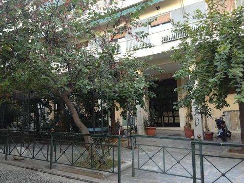 un albero di fronte a un edificio con recinto di Be My Guest Apartment ad Atene