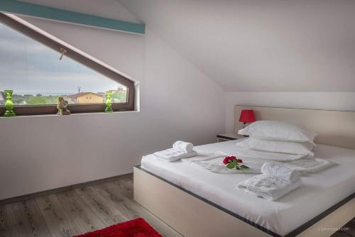a bedroom with a bed with white sheets and a window at Pensiunea Daiana in Mamaia Nord