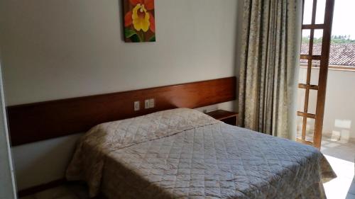 a small bedroom with a bed and a window at Quiriri Park Hotel in Prado